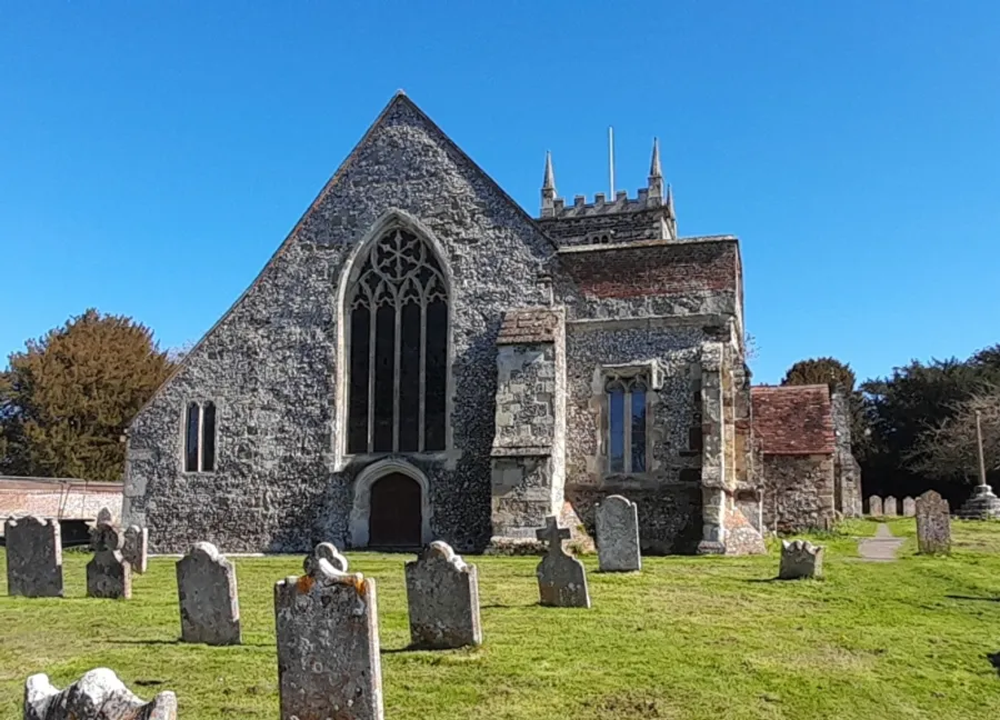 East end of St Laurence Church, Downton, with the chancel window facing a churchyard of headstones