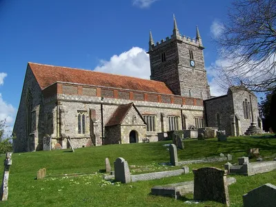 South side and tower of St Laurence Church, Downton, above a sloping churchyard